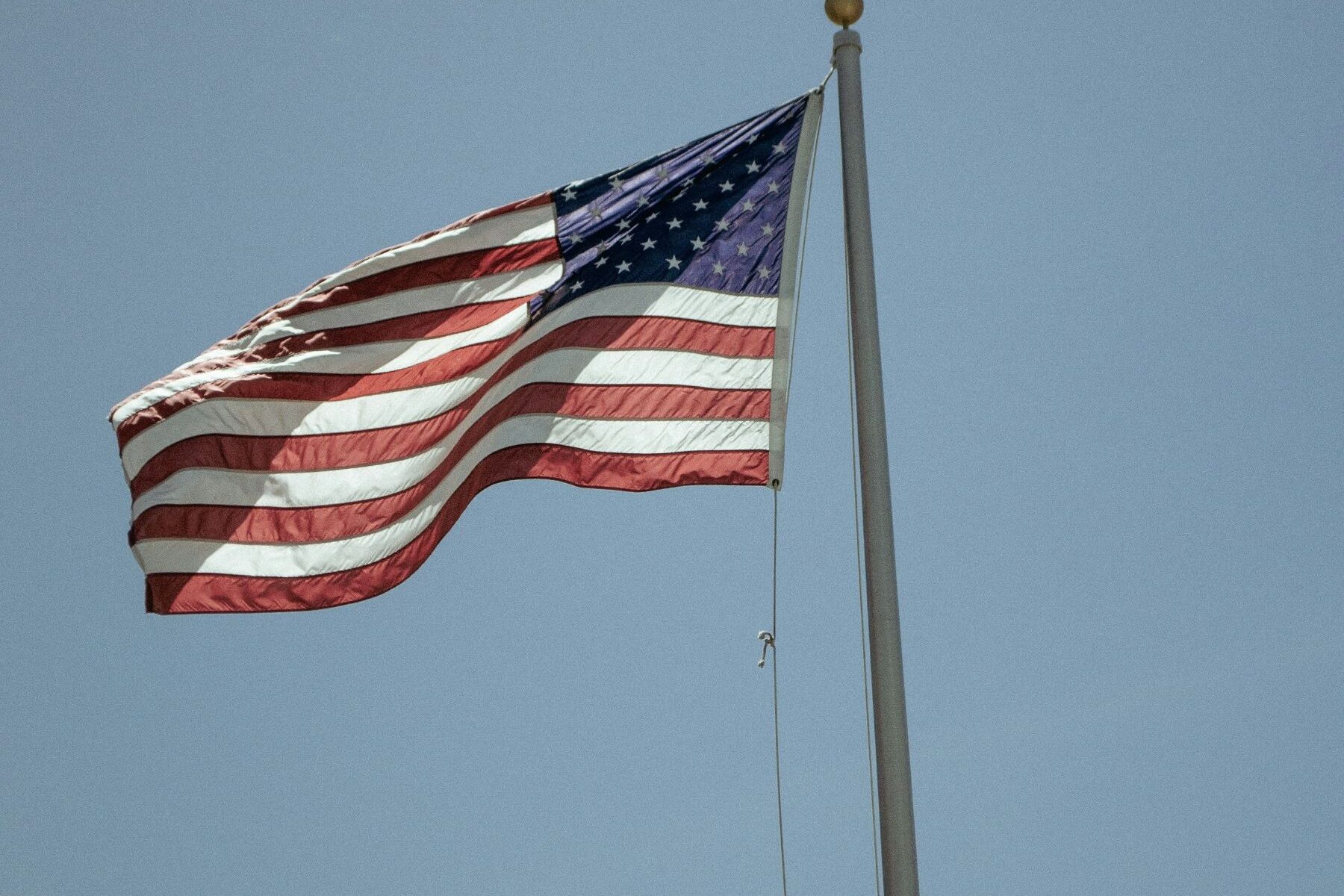 Photo of an American Flag flying on a flagpole.