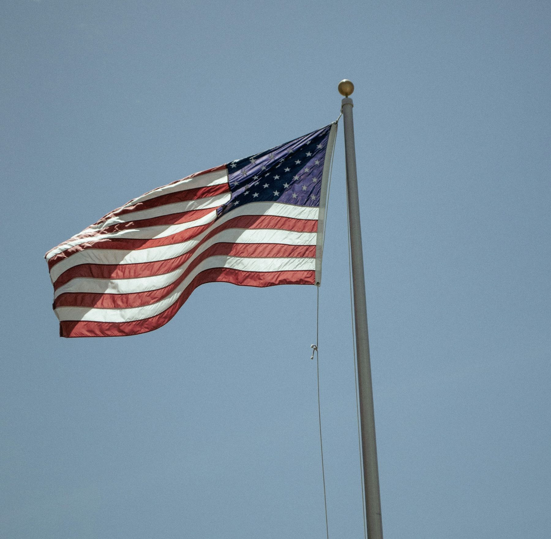 Photo of an American Flag flying on a flagpole.